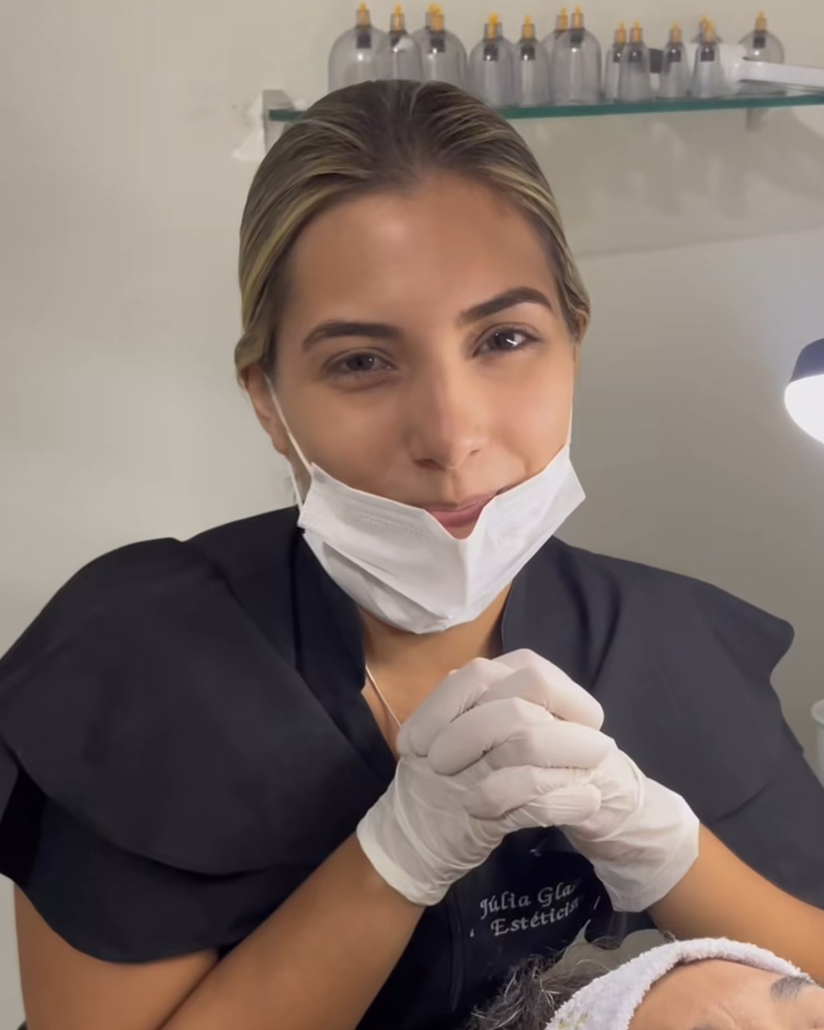 Júlia Glasner atendendo em ambiente clean, uniforme preto